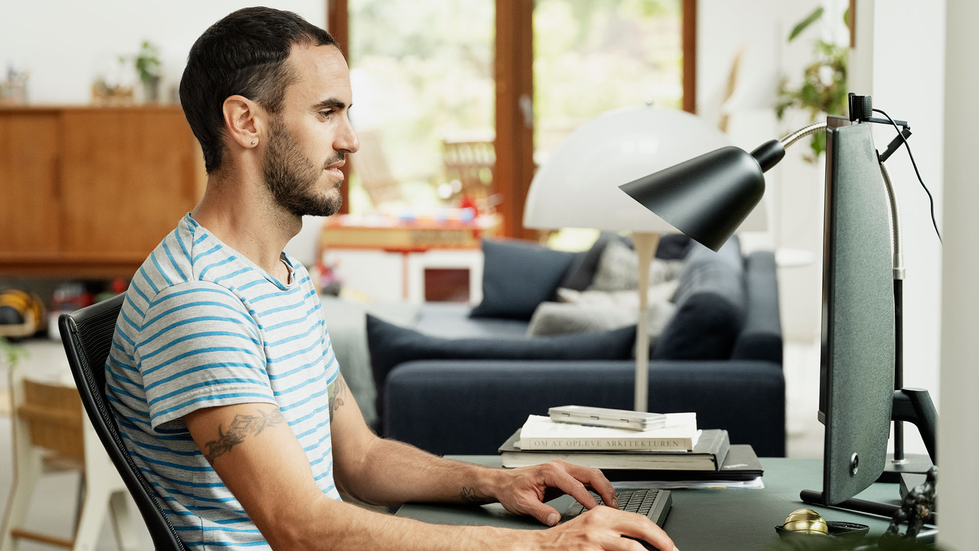 Mand sidder foran computeren, som også er dækket af indboforsikringen.
